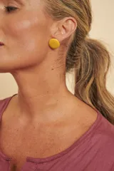 Aros tipo botón grandes, redondos y planos, en color amarillo mostaza.