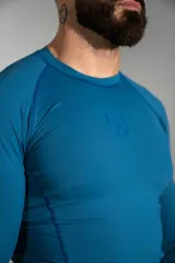 Remera deportiva de manga larga confeccionada en lycra color azul, de corte ajustado y diseño liso con costuras reforzadas.