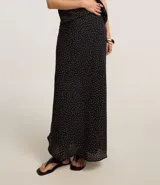 Pollera midi de corte recto confeccionada en crepé negro con estampado de lunares blancos. Presenta un diseño de caída fluida con forro interior, ideal para un look sofisticado.