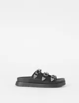 Sandalia tipo slide de plataforma color negro, con tres tiras horizontales ajustables mediante hebillas metálicas plateadas con punteras decorativas.