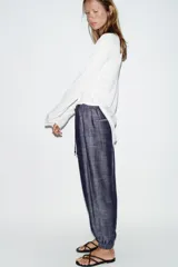 Pantalón jogger de tiro bajo color azul marino con efecto melange, cintura elástica con cordón de ajuste, bolsillos delanteros y puños elásticos en los tobillos.