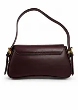 Cartera de hombro tipo baguette en color negro, con diseño curvo y solapa frontal. Incluye herrajes metálicos dorados y dos correas intercambiables, una corta para llevar al hombro y otra larga ajustable para usar cruzada.