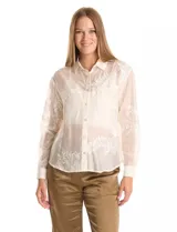 Camisa de tencel color blanco roto, semitransparente, con bordados florales en blanco. Tiene cuello con solapa, cierre frontal con botones decorados y un bolsillo en el pecho.