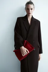 Abrigo oversize de Zara Woman Collection confeccionado en hilatura con lana. Presenta cuello con solapa de muescas, manga larga, bolsillos con solapa en el delantero y cierre frontal cruzado con botones.