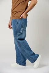 Jean baggy de color azul claro, estilo carpintero, con bolsillos laterales utilitarios y corte ancho de pierna recta.