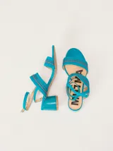 Sandalias de gamuza color bordó con taco bloque de charol, tiras con pespuntes artesanales en cuero y tira fina ajustable al tobillo.
