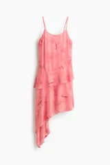 Vestido corto de gasa liviana rosado con estampado floreado, escote redondo pronunciado y breteles finos ajustables. Presenta un volado asimétrico amplio en la cintura y bajo asimétrico.