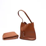 Cartera tipo bucket color marrón con textura símil cuero, asa corta y cierre con cordón ajustable. Incluye un sobre con cierre.