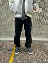 Pantalón de jean negro de corte recto, con bolsillos laterales y traseros, y presilla lateral para herramientas.