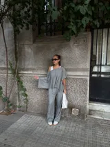 Blusa de lanilla gris con diseño asimétrico de un solo hombro y corte holgado tipo capa.