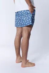 Short de baño celeste con estampado de corales blancos.
