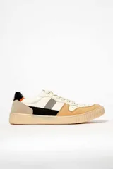 Zapatillas deportivas de cuero color crema con detalles en beige, negro y naranja.