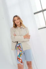 Camisa color avellana de cuero ovino italiano, de corte recto, con cuello camisero, cierre frontal con botones a presión y bolsillo de parche en el pecho.