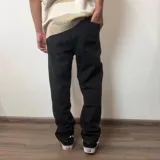 Pantalón de jean corte mom en color negro, de tiro medio y ajuste holgado en las piernas.