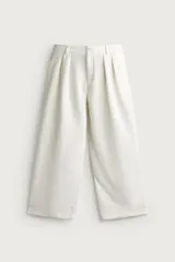Pantalón relaxed fit de color blanco off-white, confeccionado en tejido con lino. Cuenta con pliegues frontales en la cintura, bolsillos delanteros y cierre frontal con cremallera y botón.