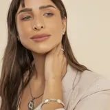 Pulsera de diseño articulado que combina eslabones de plata trenzada con detalles en oro y piezas circulares de nácar engarzadas.