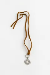 Collar con cordón de cuero tostado y dije metálico de acero en forma de sol.