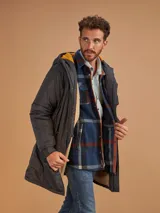 Campera de abrigo azul marino con capucha, cierre frontal con botones y cremallera, múltiples bolsillos y forro interior naranja.