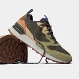 Championes Merrell modelo Alpine 83, con diseño inspirado en el senderismo retro. Presentan una combinación de gamuza y tela en tonos verde oliva, beige y marrón, con suela de goma y cordones técnicos.