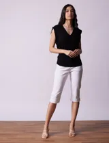 Buzo tejido en hilado fino color beige, con escote en V y sin mangas.