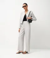 Pantalón de sastrería modelo wide leg, color gris claro, con cintura estructurada, bolsillos delanteros y traseros.