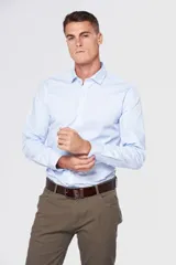 Camisa celeste de vestir, entallada, de manga larga, con cuello clásico y sin bolsillo.