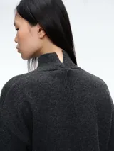Sweater de cuello alto confeccionado en tejido de lana y cachemira, de corte holgado con mangas largas y terminaciones acanaladas en puños y ruedo.