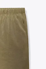 Pantalón tipo palazzo de corte recto y tejido fluido, color naranja. Presenta cintura elástica con cordón ajustable y bolsillos laterales.