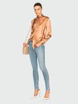 Pantalón de jean elastizado celeste, corte skinny, con bolsillos delanteros y traseros, y una franja vertical rosada en los laterales.