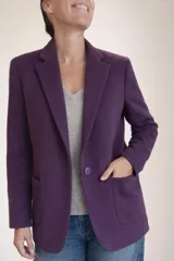 Blazer de corte oversize confeccionado en baby alpaca, color morado. Presenta solapas clásicas, cierre frontal con un botón al tono y dos bolsillos de parche delanteros.