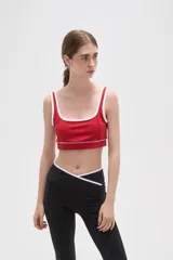Top deportivo negro con detalles de ribete blanco en el escote y breteles. Presenta un diseño de corte cuadrado y ajuste al cuerpo.