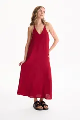 Vestido largo negro de corte holgado, con escote en V y tirantes finos tipo halter.