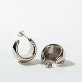 Par de aros tipo argolla gruesa, color plateado, con cierre de mariposa.