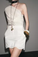 Bermuda negra de tiro alto confeccionada en hilatura de algodón con bordados perforados a tono, forro interior y cierre con cremallera oculta en costura.