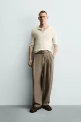 Pantalón de corte balloon fit en color gris, confeccionado en tejido con viscosa. Presenta pliegues frontales, cintura con cinturón integrado a contraste, bolsillos laterales y bolsillos traseros de vivo.