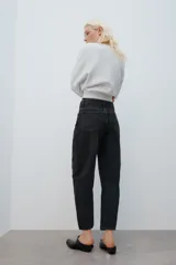 Jeans de tiro medio con diseño de volumen crop y perneras curvas. Presenta cinco bolsillos, cierre frontal con cremallera y botón metálico.