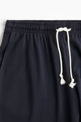 Pantalón de jogging azul marino, de corte amplio, con cintura elástica ajustable con cordón y bolsillos laterales.