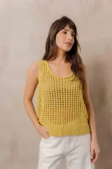 Chaleco tejido calado de color amarillo, con escote redondo, tirantes anchos y calce relajado. Cuenta con terminaciones en rib en el ruedo.