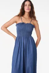 Enterito denim de algodón color azul, con escote nido de abeja, breteles finos y detalle de volado superior. Presenta pierna ancha tipo palazzo de corte relajado.