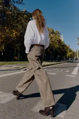 Camisa de corte amplio y estilo oversize, confeccionada en tejido tipo Oxford. Presenta cuello solapa con botones, cierre frontal abotonado, mangas largas con puños estructurados y bajo asimétrico.