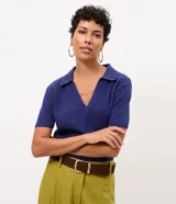 Blusa de tricot color azul, con escote en V, cuello polo, manga corta y bolsillo frontal.
