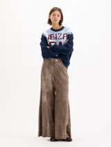 Pantalon de cuero ovino gris con diseño de pata ancha y recortes geométricos a la altura de las rodillas.