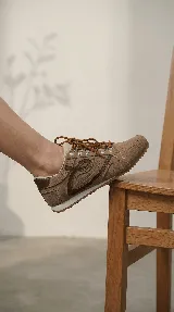 Zapatilla de cuero con diseño minimalista, cordones al tono y detalles de costuras laterales. Cuenta con suela plana y estructura ligera.