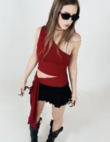 Top asimétrico color borgoña, con un solo tirante y corte irregular en la cintura.