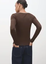 Camiseta entallada de manga larga color marrón, con escote en V y ribete en contraste de color blanco.