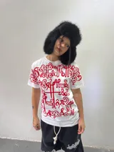 Remera blanca de corte regular con estampado frontal de gran tamaño en color rojo, con diseño de caligrafía abstracta. Confeccionada en algodón de alto gramaje, cuenta con cuello reforzado y grifa de la marca en la manga.