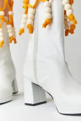 Botas de caña media de cuero metalizado con punta redonda, taco bloque y cierre en el costado interior.