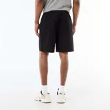 Bermuda tipo chino de color negro, confeccionada en tejido de algodón, con bolsillos laterales y cordón ajustable en la cintura.