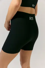 Short deportivo negro de tejido de morley con cintura ancha y logo a contratono en la cintura trasera.