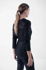 Mono largo negro con lentejuelas, escote en V cruzado, mangas largas y corte ajustado.